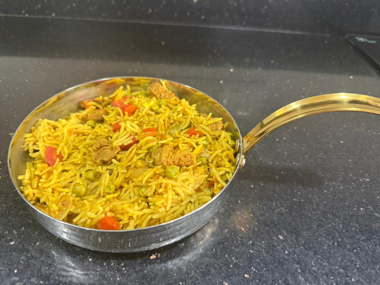 Soya chaap pulao with peas and tomato, served in a steel pan
