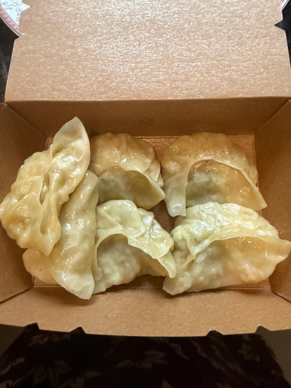 Steamed veg momos packed in a kraft takeaway box